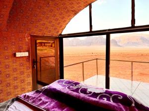 瓦迪拉姆的住宿－Wadi Rum Shooting Stars Camp，客房设有可欣赏沙漠景色的窗户。