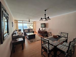 - un salon avec une table, des chaises et un canapé dans l'établissement By the Beach & Pool Apartment, à Funchal