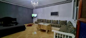 uma sala de estar com um sofá e uma mesa em luxe appartement Nour D'asilah 3 Free WiFi 5G em Asilah