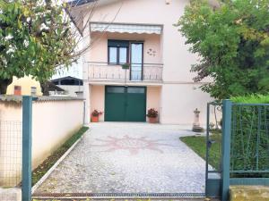 a house with a green door and a driveway at GIOIA NELLE SELVE Family House - Casa Vacanze in Mogliano Veneto