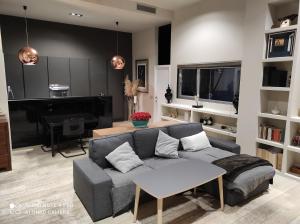 een woonkamer met een bank en een piano bij Habitación y baño en planta independiente en centro de sevilla in Sevilla