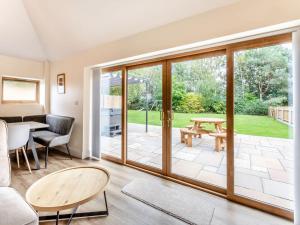 a living room with sliding glass doors leading to a patio at Tawny Acre Barn - Uk38614 in Wisbech