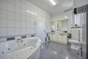 a bathroom with a tub and a sink and a toilet at ASTAREA - penthouse in green & nature - hot tub - free private parking - terrace - peace in Zagreb