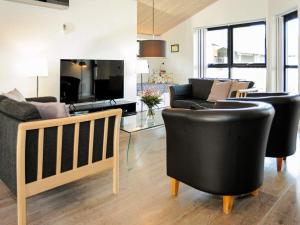 a living room with black chairs and a couch at 8 person holiday home in Ansager in Ansager