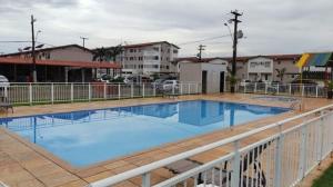 une grande piscine bleue avec clôture et bâtiments dans l'établissement Apartamento 4 andar Completo em Condomínio Residencial Familiar, à Porto Velho