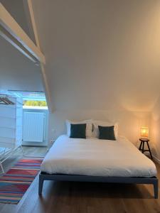 un letto bianco in una stanza con finestra di Maison Georges a Turnhout