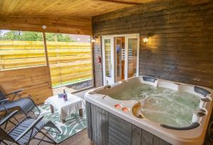 a jacuzzi tub on the deck of a cabin at Au coucher du soleil, chalet avec jacuzzi et sauna in Vieux-CondÃ©