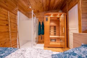 a bedroom with a bed and a walk in closet at Au coucher du soleil, chalet avec jacuzzi et sauna in Vieux-CondÃ©