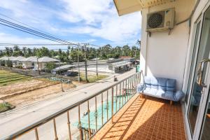 a balcony with a couch and a view of a street at Arena Seaview in Baan Tai