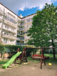 Un parque infantil frente a un edificio con un tobogán. en Santos 1214 Apartment, en Budapest