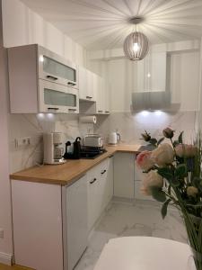 a kitchen with white cabinets and a counter top at J. Kuperjanov Apartment in Tartu
