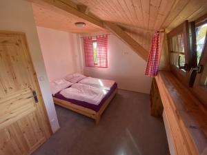 a bedroom in a tiny house with a bed at Apartmány Pod Kopcem in Bublava