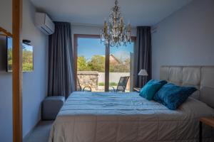 a bedroom with a bed with blue pillows and a window at Muelles del Diablo Tranquilo in Punta Del Diablo +58 photos
