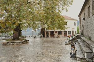 a park with benches and a tree and a building at Country house 2 in Ktistádes