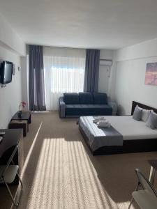 una camera d'albergo con letto e divano di Cristiana Studio Eforie Nord a Eforie Nord