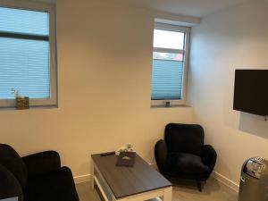 a living room with two chairs and a table and a tv at MR Ferienwohnung - Wohnung Greta in Schellerten