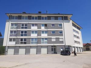 a large building with a car parked in front of it at Apartmani Ivona in Kupres