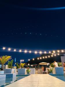 um pátio com cadeiras e luzes à noite em Hotel Cabo Branco Atlântico em João Pessoa