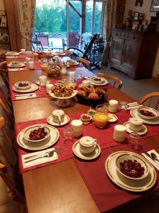 uma mesa longa com pratos de comida em Chambres d'Hôtes La Chouette em Sainte-Anne-Saint-Priest