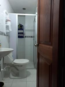 een badkamer met een toilet en een glazen douche bij Casa Gloria in Medellín