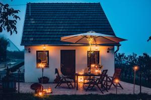 a patio with a table and an umbrella and chairs at Barbár Borbár in Szekszárd