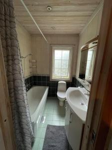 a bathroom with a tub and a toilet and a sink at Large cozy villa between Stockholm and Oslo in Åmotsfors