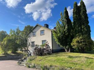 Large cozy villa between Stockholm and Oslo في Åmotsfors: بيت ابيض وامامه اشجار