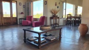 a living room with a coffee table and red chairs at Celestino Posta Andina in Barreal