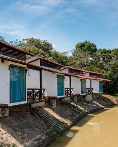 a row of houses on the side of a river at Hacienda Don Vicente Bungalows-Tarapoto in Tarapoto