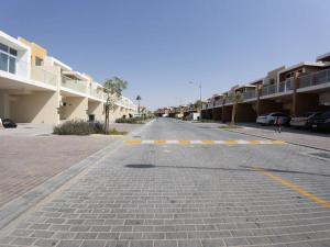 an empty street next to a row of buildings at Brand new luxury 3bedroom villa in Damac Hills 2 in Dubai