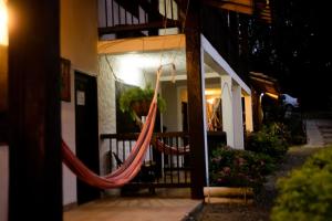 a person sitting in a hammock outside of a building at Finca Hotel Loma Verde in Quimbaya