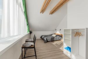 Zimmer mit einem Stuhl, einem Bett und einem Fenster in der Unterkunft Chata Zdiarka 4M in Ždiar