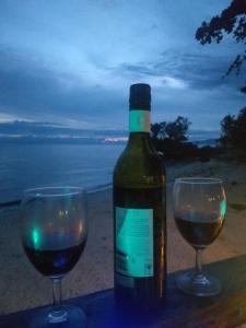 Una botella de vino y dos copas en una mesa. en Casa de Corazon, en Kandabong