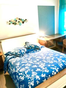Un dormitorio con una cama azul y blanca con almohadas en BedinReims "blue bottle"quiet and close to center free parking and wifi free ideal 5 à 6 Adultes, en Reims