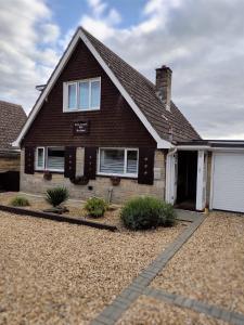 a brown house with a white garage at Little Bassett Bed & Breakfast in Totland