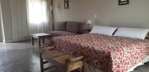 a bedroom with a bed and a couch at Celestino Posta Andina in Barreal