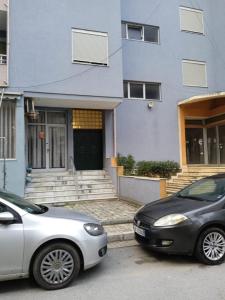 two cars parked in front of a house at Apartment Durres in Durrës