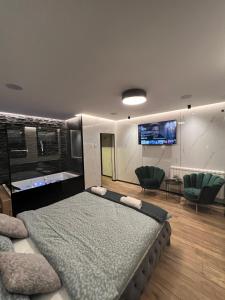 斯科普里The Pearl - In the heart of Skopje的一间卧室配有一张大床和两张绿色椅子