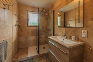 uma casa de banho com um lavatório e um chuveiro em Belle maison rénovée, 5mn à pied de la mer, classée meublé de tourisme 3 étoiles em Île-Tudy