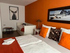 een slaapkamer met een bed met oranje muren bij Residence Cocoon in Brixen im Thale