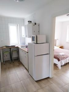 a kitchen with a refrigerator and a table and a bed at Napkő in Kőszeg