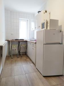 eine Küche mit einem weißen Kühlschrank und einem Tisch in der Unterkunft Napkő in Kőszeg