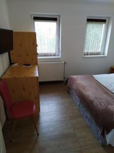 Schlafzimmer mit einem Bett, einem Schreibtisch und einem Stuhl in der Unterkunft Napkő in Kőszeg