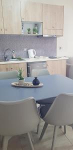 a kitchen with a blue table and chairs and a table and chairs at Joanna Apartments in Bali