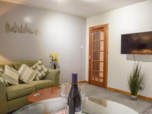 Roseville Annex في Markinch: غرفة معيشة مع زجاجة من النبيذ على طاولة