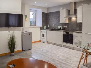 a kitchen with white appliances and a table in a room at Roseville Annex in Markinch