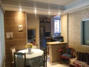 ein Wohnzimmer mit einem Tisch und einer Küche in der Unterkunft Casa 2 Encanto dos Mares in Itapema
