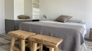 una camera con un letto e due panche in legno di Moderno depto frente al río! a San Nicolás de los Arroyos