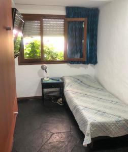 a small bedroom with a bed and a window at Departamento Mar Punta del Este in Punta del Este