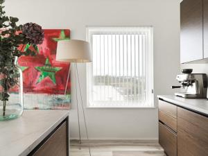 a kitchen with a table with a lamp and a window at Modern Luxury Apartment - Ocean & Mountain Views in Reykjavík